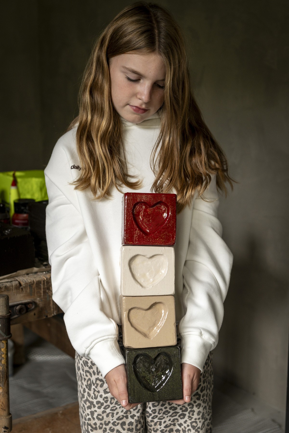 Melle Mae met een stapel van haar rode, witte, beige en groene hartjesblokken
